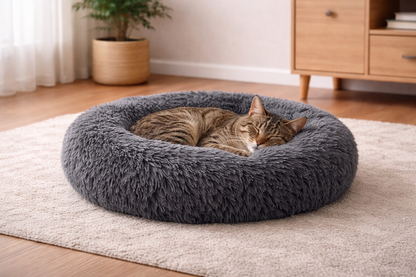 Chat tigré endormi dans le coussin NUA gris ultra moelleux, confort enveloppant dans un intérieur moderne et apaisant